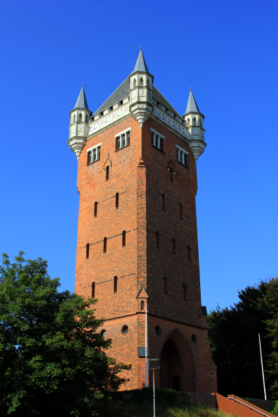 Et højt rådstenstårn, med en hvid krone med tårne i hjørnerne.